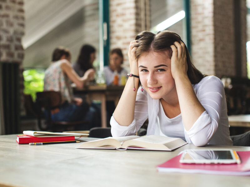 lovely teen with books posing camera